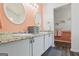 Bathroom with double sinks, decorative mirrors and granite countertops, and peachy walls at 90 Harlin Ct, Covington, GA 30014