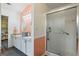 Bathroom with a glass shower, double sinks, granite countertops, a peach accent wall, and gray floors at 90 Harlin Ct, Covington, GA 30014