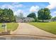 Wide concrete driveway leading to a well-maintained home with lush green lawns and mature trees at 90 Harlin Ct, Covington, GA 30014