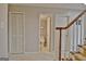 Hallway with staircase, linen closet, and a view into the half bathroom with a tiled floor at 26 Cobblestone Crk, Peachtree City, GA 30269