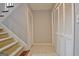 Spacious hallway with neutral tile floors, storage closets, and a carpeted staircase at 26 Cobblestone Crk, Peachtree City, GA 30269