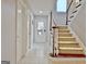 View of a hallway with a staircase, white doors, and tile flooring that gets lots of natural light at 26 Cobblestone Crk, Peachtree City, GA 30269