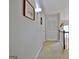 Hallway with neutral paint and carpeting leads to bedrooms and other living areas at 26 Cobblestone Crk, Peachtree City, GA 30269