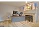 Home office with fireplace, modern desk setup, and hardwood floors at 26 Cobblestone Crk, Peachtree City, GA 30269
