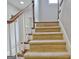 Carpeted staircase with wooden banister and white spindles leading to the upper level at 26 Cobblestone Crk, Peachtree City, GA 30269
