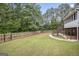 Spacious backyard with grass and a fence featuring stairs to a deck with screened porch below at 1085 Crown River Pkwy, Mcdonough, GA 30252