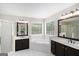 Double sink vanity with soaking tub in a naturally lit primary bathroom at 1085 Crown River Pkwy, Mcdonough, GA 30252