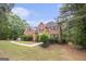 Well-maintained brick home with manicured landscaping, mature trees, and a lush green lawn at 1085 Crown River Pkwy, Mcdonough, GA 30252