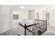 Upstairs hallway with decorative metal railing, neutral paint, and plush carpet at 1085 Crown River Pkwy, Mcdonough, GA 30252