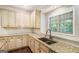 Well-lit kitchen showcasing granite counters, custom cabinetry, and a stainless sink at 1085 Crown River Pkwy, Mcdonough, GA 30252