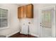 Bright laundry room featuring wood cabinets and connections for washer and dryer at 1085 Crown River Pkwy, Mcdonough, GA 30252