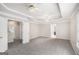Expansive main bedroom with tray ceilings, ceiling fans, and plush neutral carpet at 1085 Crown River Pkwy, Mcdonough, GA 30252