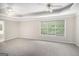 Large main bedroom with tray ceiling, plush carpet, and large window with backyard views at 1085 Crown River Pkwy, Mcdonough, GA 30252