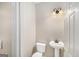 Classic powder room with pedestal sink, toilet, and decorative wall sconce at 1085 Crown River Pkwy, Mcdonough, GA 30252