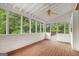 Relaxing screened porch with wood floors, ceiling fan, and wooded backyard views at 1085 Crown River Pkwy, Mcdonough, GA 30252