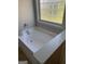 Soaking tub with unique window, perfect for relaxation and privacy in this tranquil bathroom at 2681 Mariner Way, Villa Rica, GA 30180