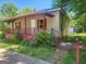 Curb view of home's front porch surrounded by flower bushes at 4 Maple St, Porterdale, GA 30014