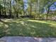 Exterior backyard with a yard, grass, trees, and partial view of the house at 9022 Homewood Dr, Riverdale, GA 30274