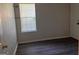 Small, empty bedroom featuring hardwood floors and a window at 9022 Homewood Dr, Riverdale, GA 30274