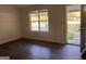 An empty living room with hardwood floors, neutral walls and a front door that leads to the yard at 9022 Homewood Dr, Riverdale, GA 30274