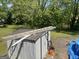 Backyard shed featuring a ladder on the roof, surrounded by trees and lush greenery at 3143 S West St, Covington, GA 30014