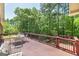 Outdoor deck with outdoor dining furniture and railing with a view of wooded backyard at 330 Noah Pl, Mcdonough, GA 30252