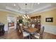 Elegant dining room with a decorative chandelier, hardwood floors, and built-in china cabinet at 330 Noah Pl, Mcdonough, GA 30252