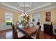 Formal dining room featuring a coffered ceiling, chandelier, and large window overlooking the yard at 330 Noah Pl, Mcdonough, GA 30252