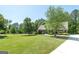 Beautifully landscaped front yard with mature trees leading to a stately brick home at 330 Noah Pl, Mcdonough, GA 30252