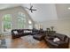 Open living room with vaulted ceiling, fireplace, large sectional sofa, area rug and hardwood floors at 330 Noah Pl, Mcdonough, GA 30252