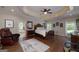 Main bedroom with tray ceiling, recessed lights, wood floors, and attached bathroom at 330 Noah Pl, Mcdonough, GA 30252