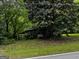 Quaint cabin exterior with mature trees, lush greenery, and covered porch at 3935 Jailette Rd, South Fulton, GA 30349