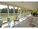 Spacious screened porch featuring tile flooring, comfortable seating, and peaceful pond views at 301 Spruill Bridge Rd, Temple, GA 30179