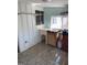 Functional kitchen with a utility sink featuring tile flooring and shelving above the sink at 1025 Lynwood Pl, Forest Park, GA 30297
