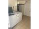 Laundry room with white washer and dryer featuring tile flooring and white walls with storage cabinets at 1025 Lynwood Pl, Forest Park, GA 30297