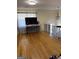 Open living area featuring hardwood floors, large TV, and ornate chandelier at 1025 Lynwood Pl, Forest Park, GA 30297