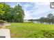 Expansive backyard with lake views, a stone patio, and lush greenery offers a serene outdoor retreat at 513 Viridian Vw, Peachtree City, GA 30269