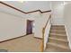 Spacious carpeted basement featuring stairs with wooden handrail, wood trim and a paneled door at 513 Viridian Vw, Peachtree City, GA 30269