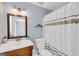 Cozy bathroom with a single sink vanity, framed mirror, blue walls, and white shower curtain at 513 Viridian Vw, Peachtree City, GA 30269