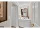 A half bathroom with modern vanity, mirror, light fixture, and a door to another room at 513 Viridian Vw, Peachtree City, GA 30269