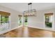 Sunlit dining room with hardwood floors, modern chandelier, and views of the landscaped yard at 513 Viridian Vw, Peachtree City, GA 30269