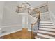 Open foyer with hardwood flooring, chandelier, and staircase with decorative wrought iron spindles at 513 Viridian Vw, Peachtree City, GA 30269