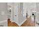 Hallway featuring hardwood floors, white trim, and access to powder room and other living spaces at 513 Viridian Vw, Peachtree City, GA 30269
