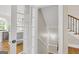 Hallway featuring kitchen view, leading to stairs with modern handrail and carpeted steps to upper levels at 513 Viridian Vw, Peachtree City, GA 30269