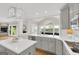 Kitchen featuring grey cabinetry, a large island with quartz countertops, and open access to an outdoor view at 513 Viridian Vw, Peachtree City, GA 30269