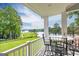 Inviting porch with golf course view, black metal table and chairs on a sunny day at 513 Viridian Vw, Peachtree City, GA 30269