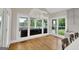 Sunroom with large windows offering views of the greenery, hardwood floors, and modern lighting fixture at 513 Viridian Vw, Peachtree City, GA 30269