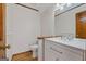 This half bath has a stylish modern vanity with a granite countertop, a large mirror, and wood look flooring at 2402 Creekside Trce, Jonesboro, GA 30236