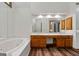 Bathroom featuring a tub, double sink vanity, a large mirror, and modern lighting at 2402 Creekside Trce, Jonesboro, GA 30236