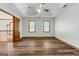 This bedroom offers hardwood-style flooring, two windows with blinds, and a ceiling fan at 2402 Creekside Trce, Jonesboro, GA 30236